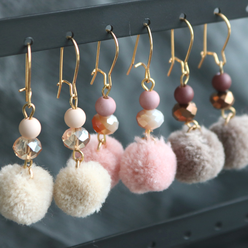 Erzeugen Sie ein WOW!-Effekt mit diesen Ohrringen aus funkelnden Facett Perlen und zarten Pompom Anh&auml;ngern mit goldenem Zubeh&ouml;r aus DQ Metall &ndash; Get the look!